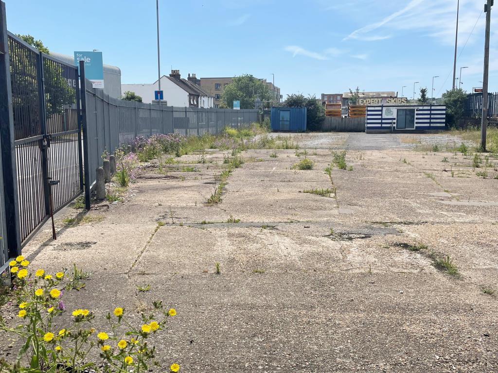 Lot: 99 - LAND WITH RESIDENTIAL PLANNING FOR 33 UNITS - Vacant site with hardstanding area and gate